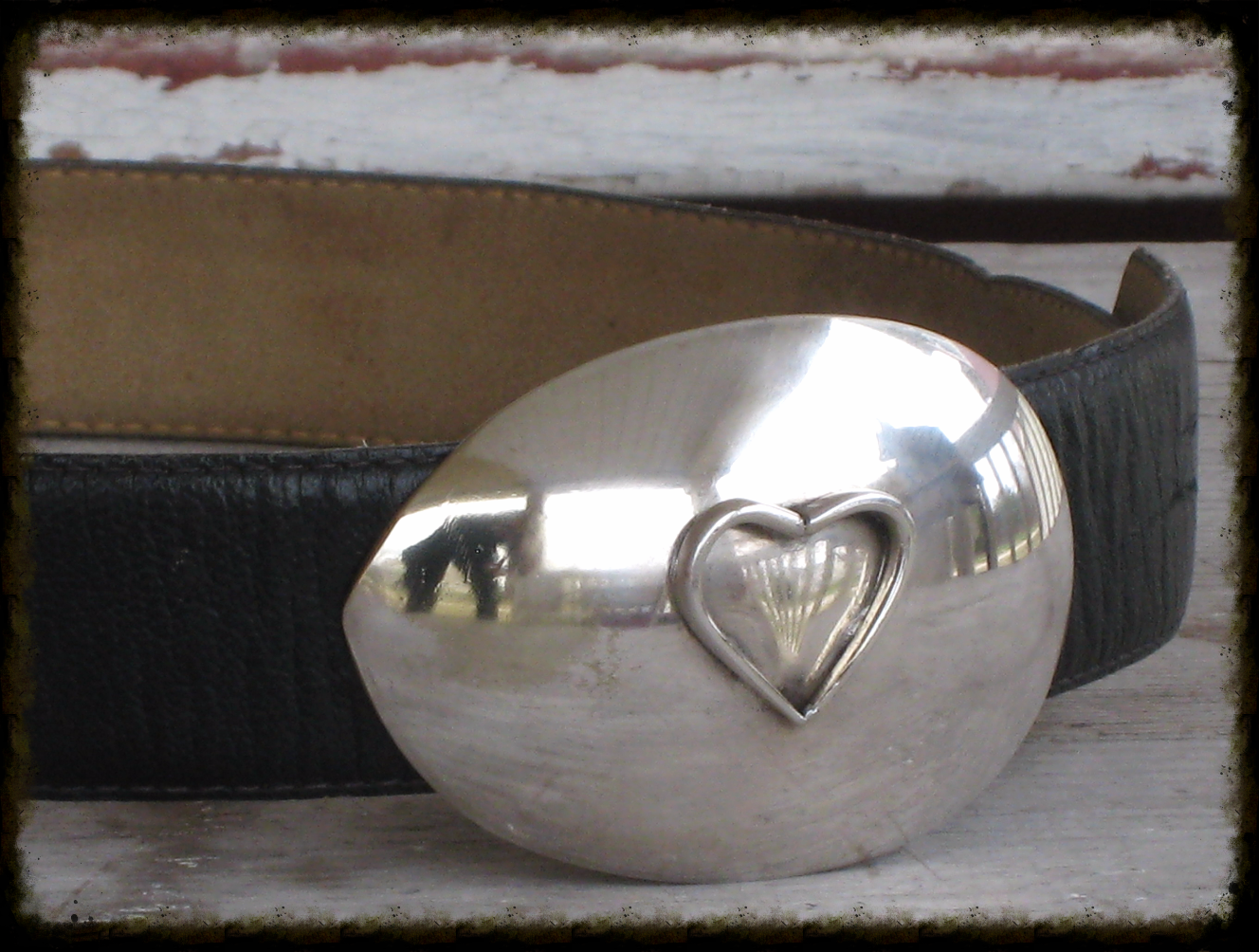 Side angle of heart spoon belt buckle showing dimensional fork-tine heart and vintage silverware pattern detail on casserole spoon