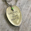 Close-up of BELIEVE IN YOUR SELFIE hand-stamped spoon pendant with playful beads showing confident message on reclaimed vintage silverware, 16-inch chain