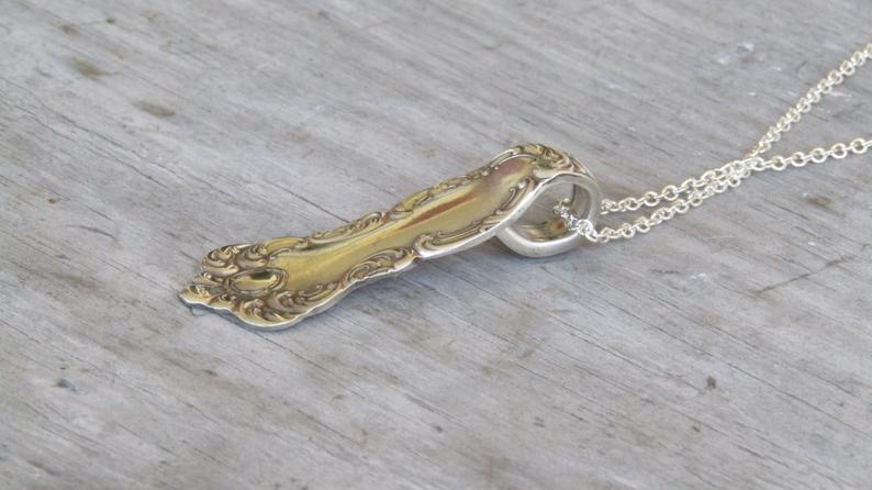 Close-up of Oxford spoon handle necklace showing self-loop hanging device and earth tone bead accents on 19-inch chain, upcycled antique silverware