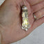 Oxford spoon handle pendant held in hand showing 2-1/8 inch size, handpolished William Rogers 1901 antique silverplate necklace