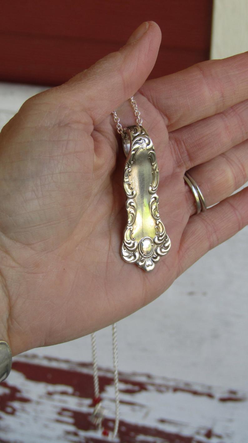 Oxford spoon handle pendant held in hand showing 2-1/8 inch size, handpolished William Rogers 1901 antique silverplate necklace