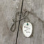 THINK LESS BE MORE stamped spoon necklace showing hand-stamped lettering and turquoise sphere bead detail, 18-inch chain, one-of-a-kind