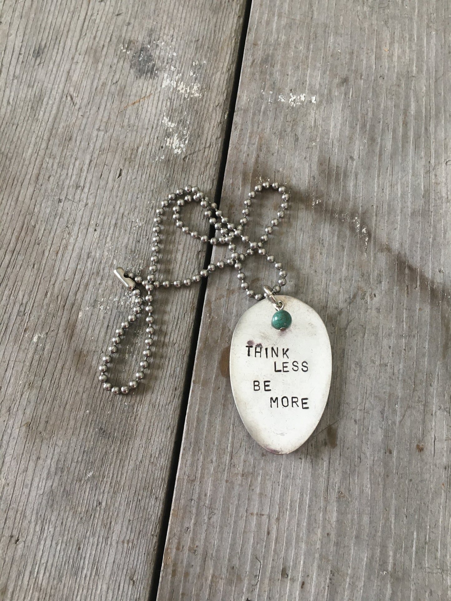 THINK LESS BE MORE stamped spoon necklace showing hand-stamped lettering and turquoise sphere bead detail, 18-inch chain, one-of-a-kind