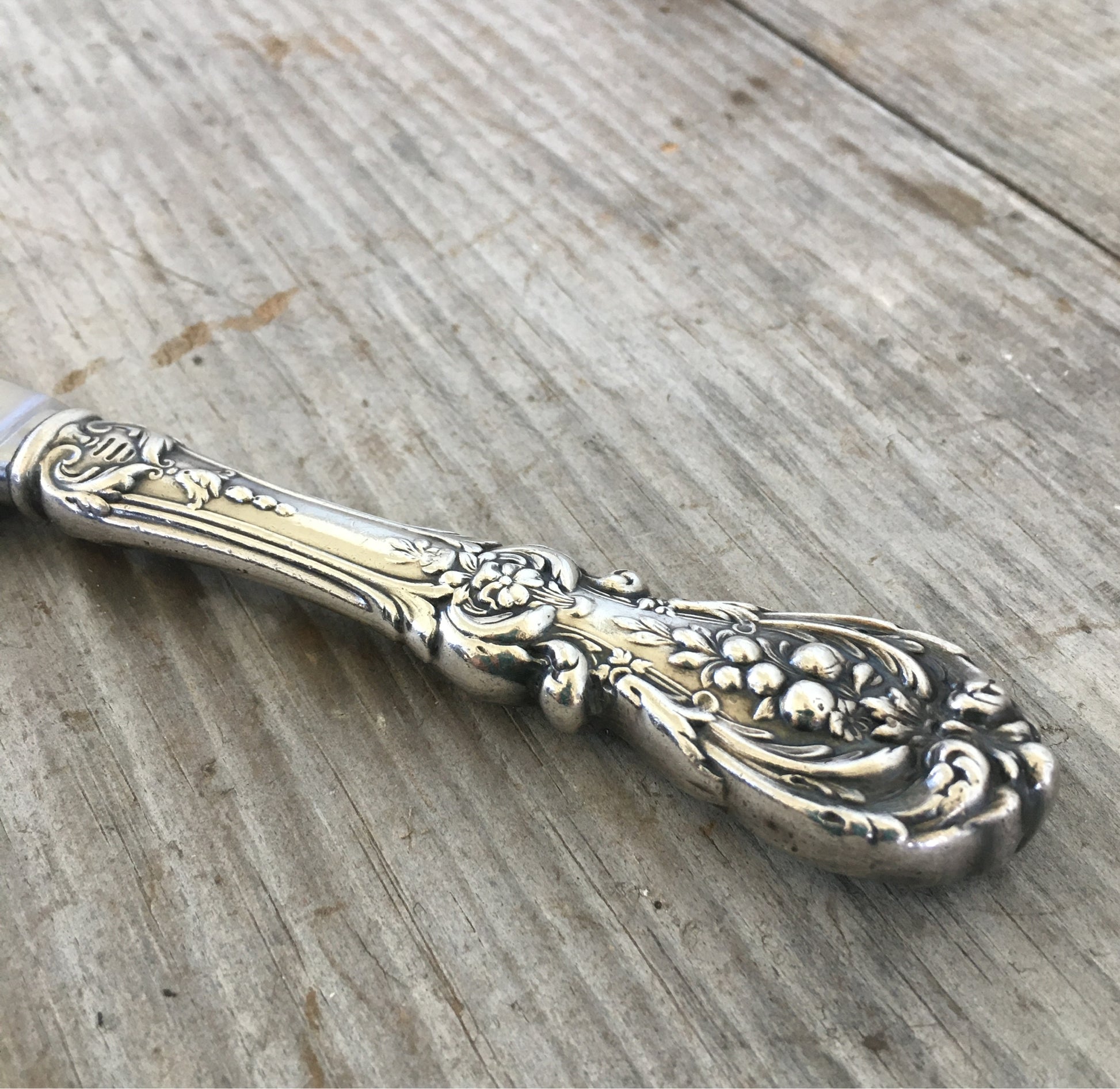 Close-up of ornate Francis I Renaissance floral pattern on Reed & Barton sterling silver charcuterie knife