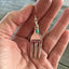 Cocktail fork earrings with teal green beads shown in hand for scale