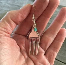 Cocktail fork earrings with teal green beads shown in hand for scale