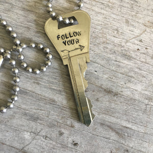 Close up of Hand Stamped Key Necklace Giving Key Follow Your Arrow