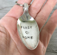 Spoon keychain hand stamped with FIRST HOME and a heart shown in hand for size and scale