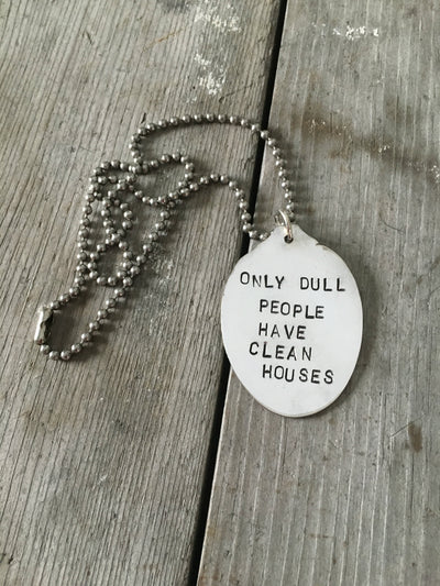 Close-up of ONLY DULL PEOPLE HAVE CLEAN HOUSES hand-stamped spoon pendant showing humorous message on reclaimed vintage silverware, 19-inch chain