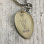 Close-up of BE A DEAR GET ME A BEER hand-stamped spoon pendant showing cheeky message on reclaimed vintage silverware, feminist humor design