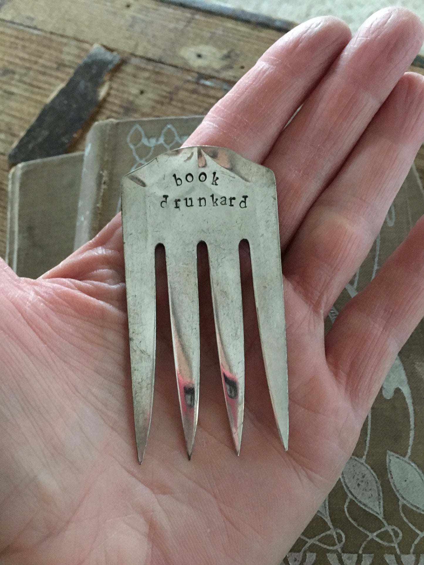 Handstamped Book Drunkard Bookmark shown in hand for size and scale