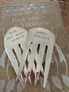 Display of two upcycled serving fork bookmarks handstamped with phrases about books