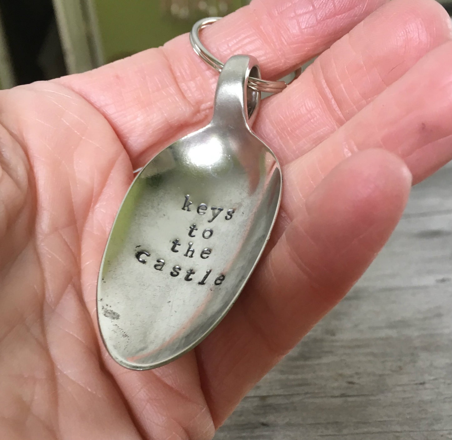 Keys To The Castle spoon keychain in hand showing size of handcrafted vintage silverware accessory