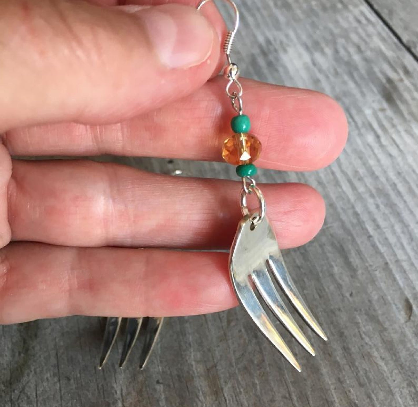 Close-up detail of cocktail fork tine earring with lavender Czech glass bead and trident prong design