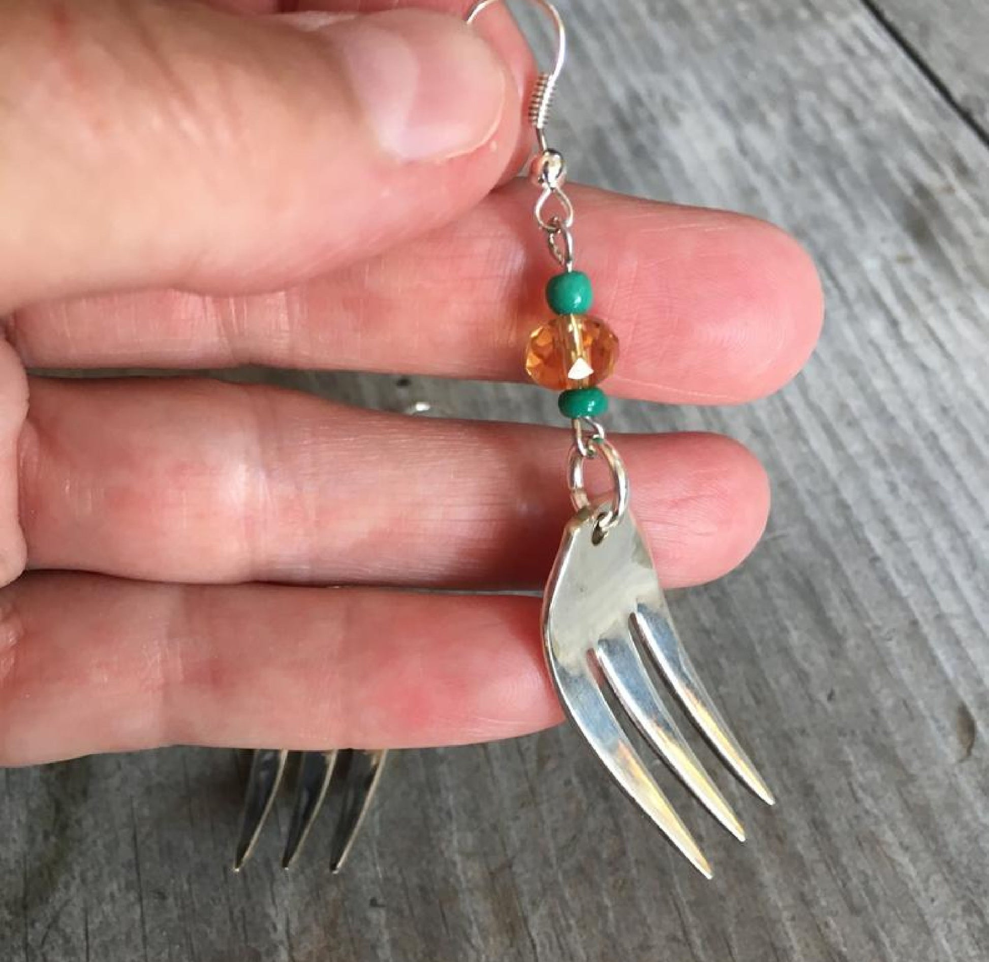 Close-up detail of cocktail fork tine earring with lavender Czech glass bead and trident prong design