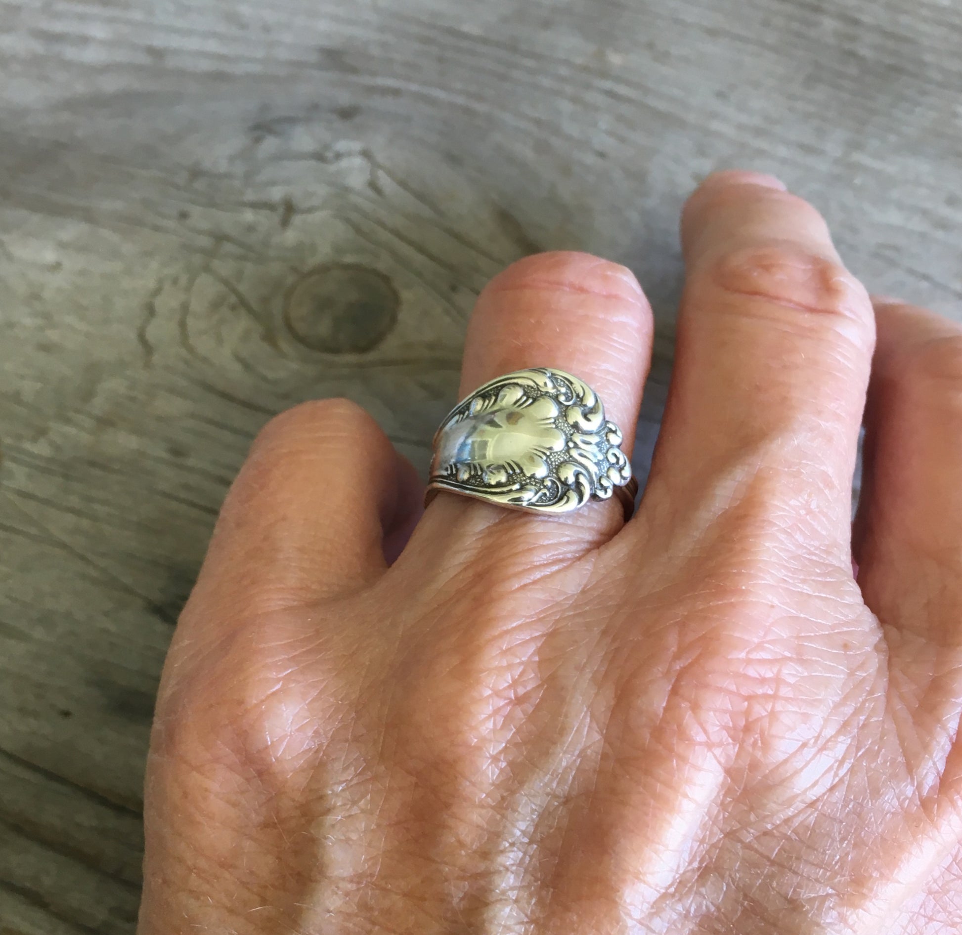 Sterling silver spoon ring on hand showing ornate scrollwork pattern and polished finish - Sterling spoon ring - handcrafted from upcycled vintage silverware - Laughing Frog Studio