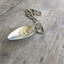 Close-up of BUT FIRST COFFEE hand-stamped spoon pendant with steaming cup showing quirky message on reclaimed vintage silverware, 18-inch chain