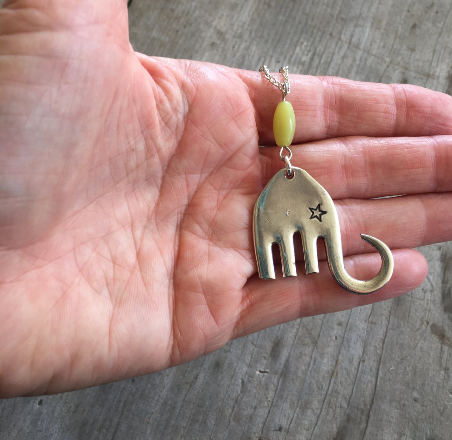 Handmade Fork Elephant Necklace Shown in hand for scale