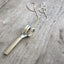 Close Up of Upcycled Fork Necklace Hand Flipping Bird