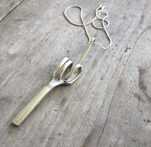 Close Up of Upcycled Fork Necklace Hand Flipping Bird