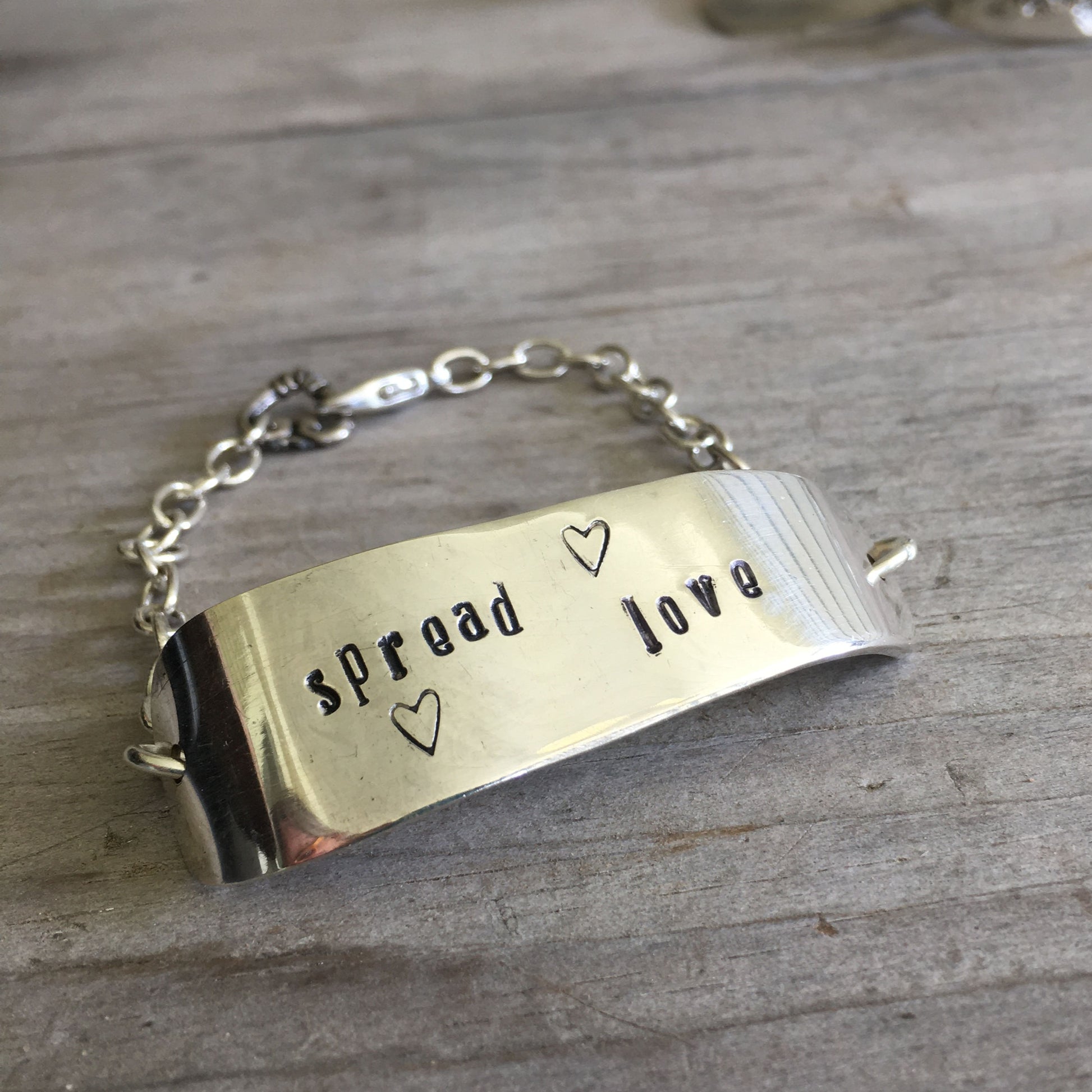 Handcrafted Spread Love hand-stamped knife bracelet with heart charm - premium upcycled vintage silverware artisan jewelry