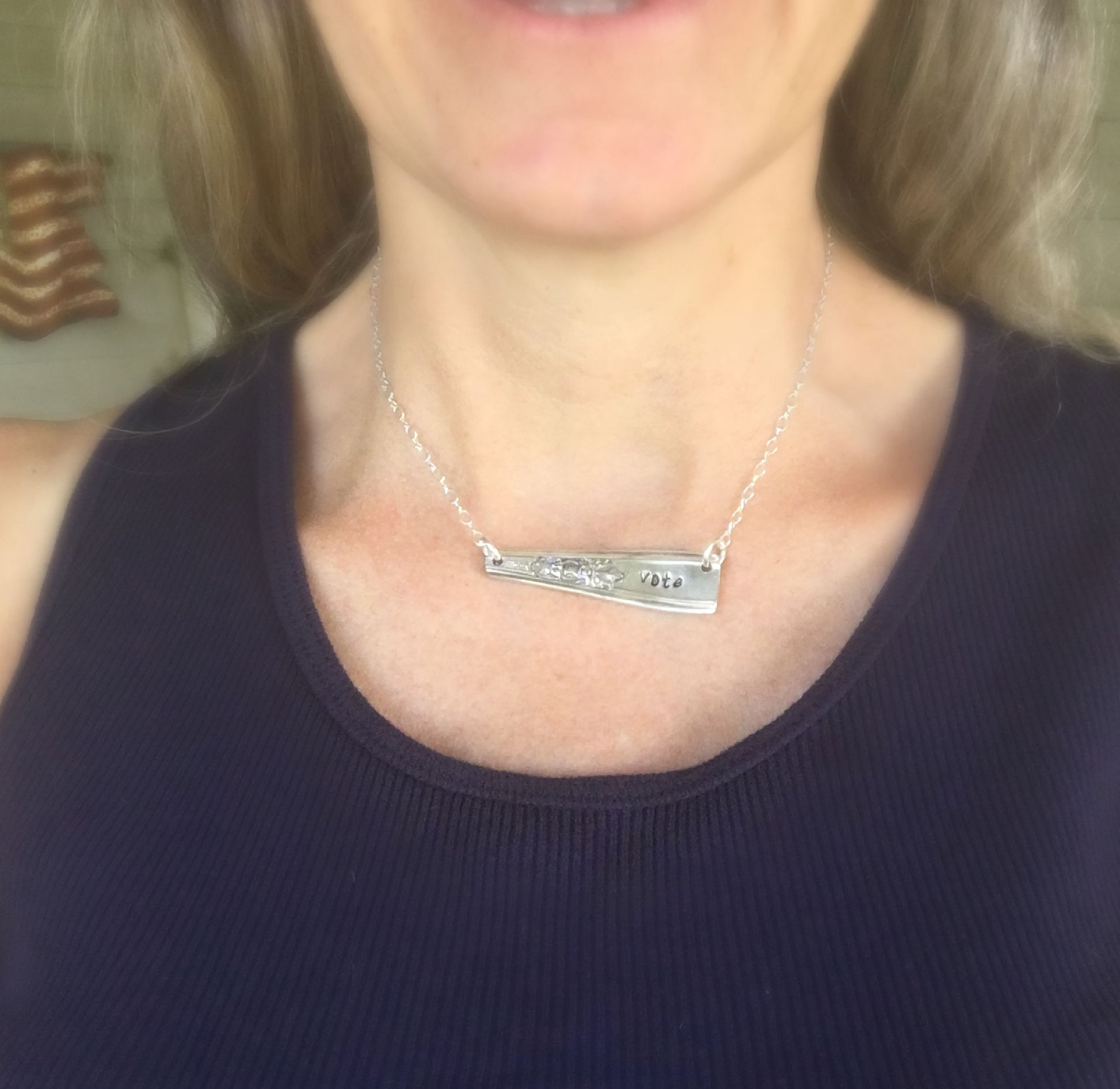 VOTE bar necklace modeled on collarbone showing choker fit and meaningful hand-stamped design, 7-inch drop
