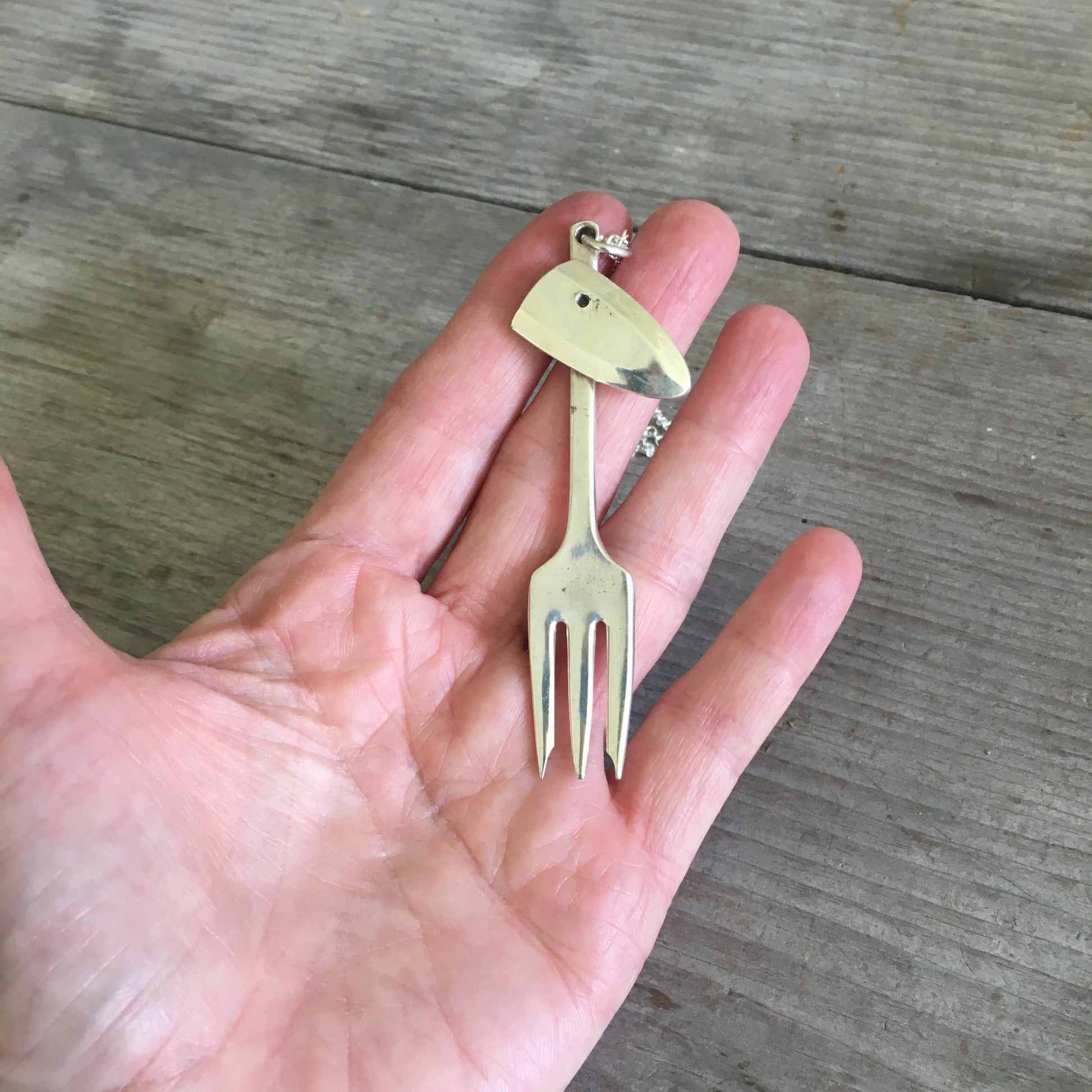 Unique upcycling necklace Cocktail Fork Giraffe shown in hand for scale