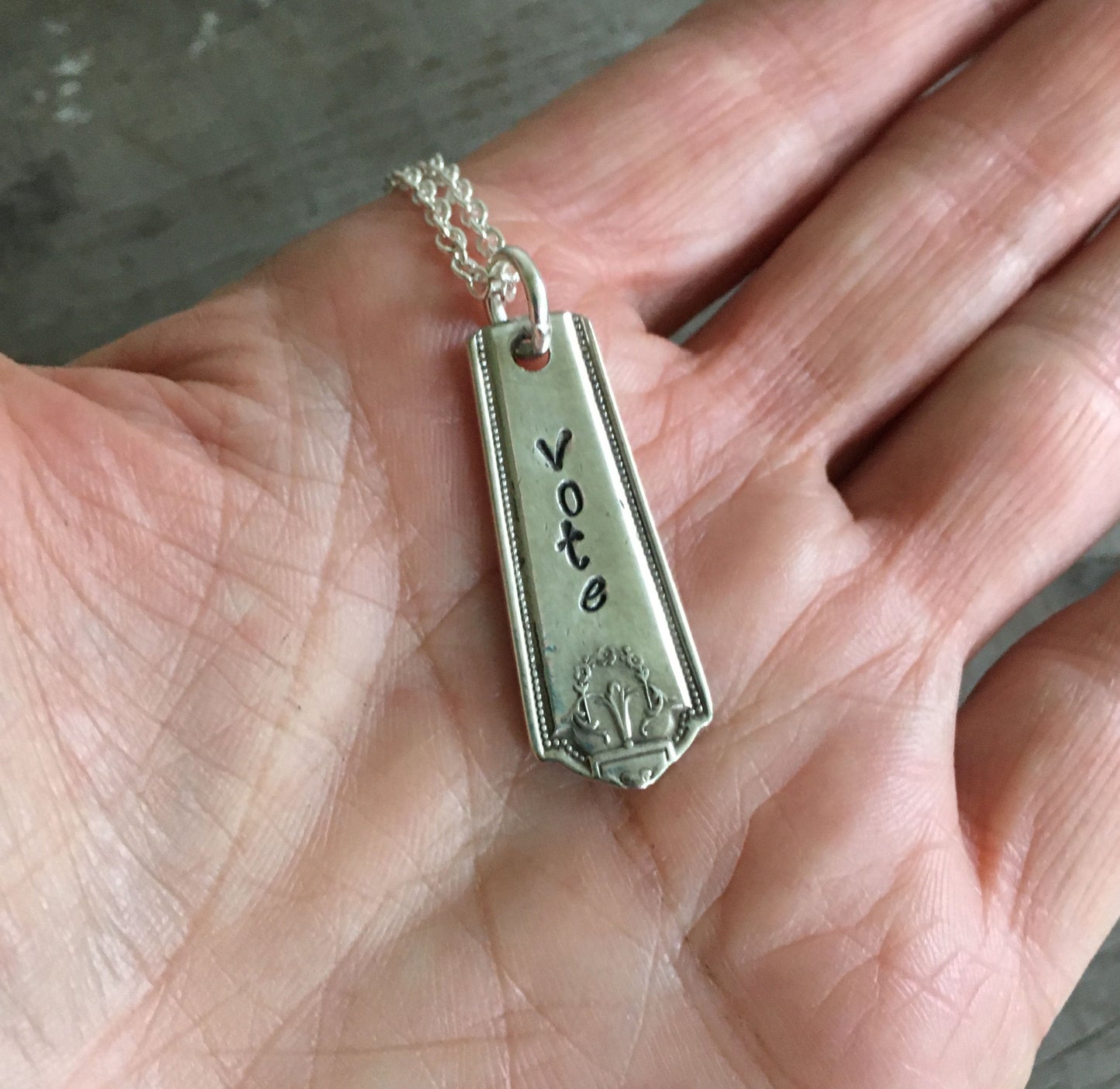 VOTE bar necklace, sustainable upcycled silverplate, shown in hand for size and scale