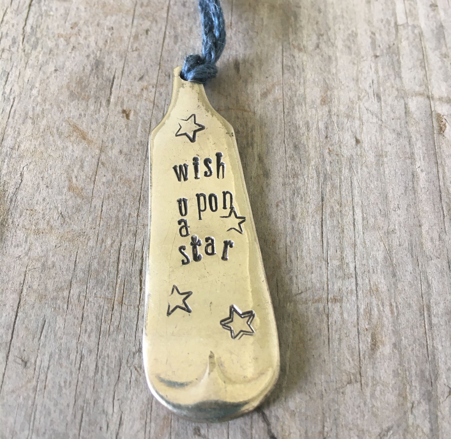 Closeup of stamping on handcrafted antique spoon bookmark stamped WISH UPON A STAR - late 1800s Fiddle pattern with handmade tassel