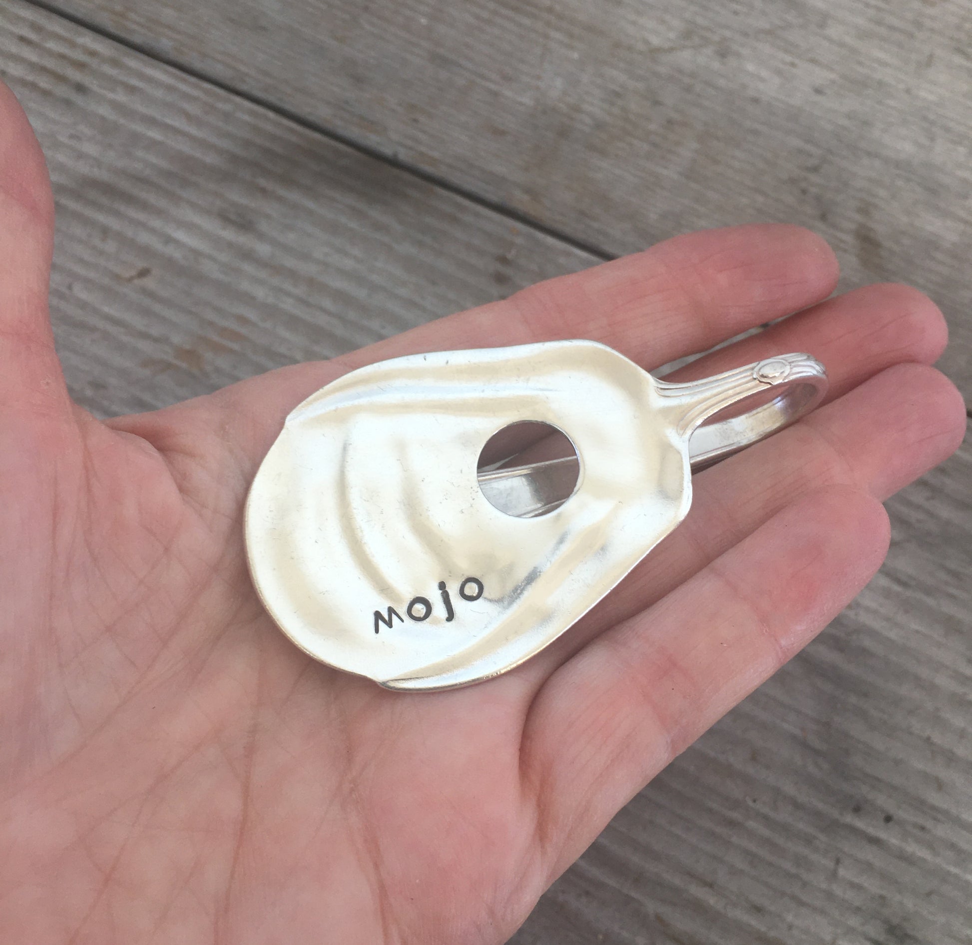 Upcycled spoon guitar money clip MOJO held in hand showing size and scale