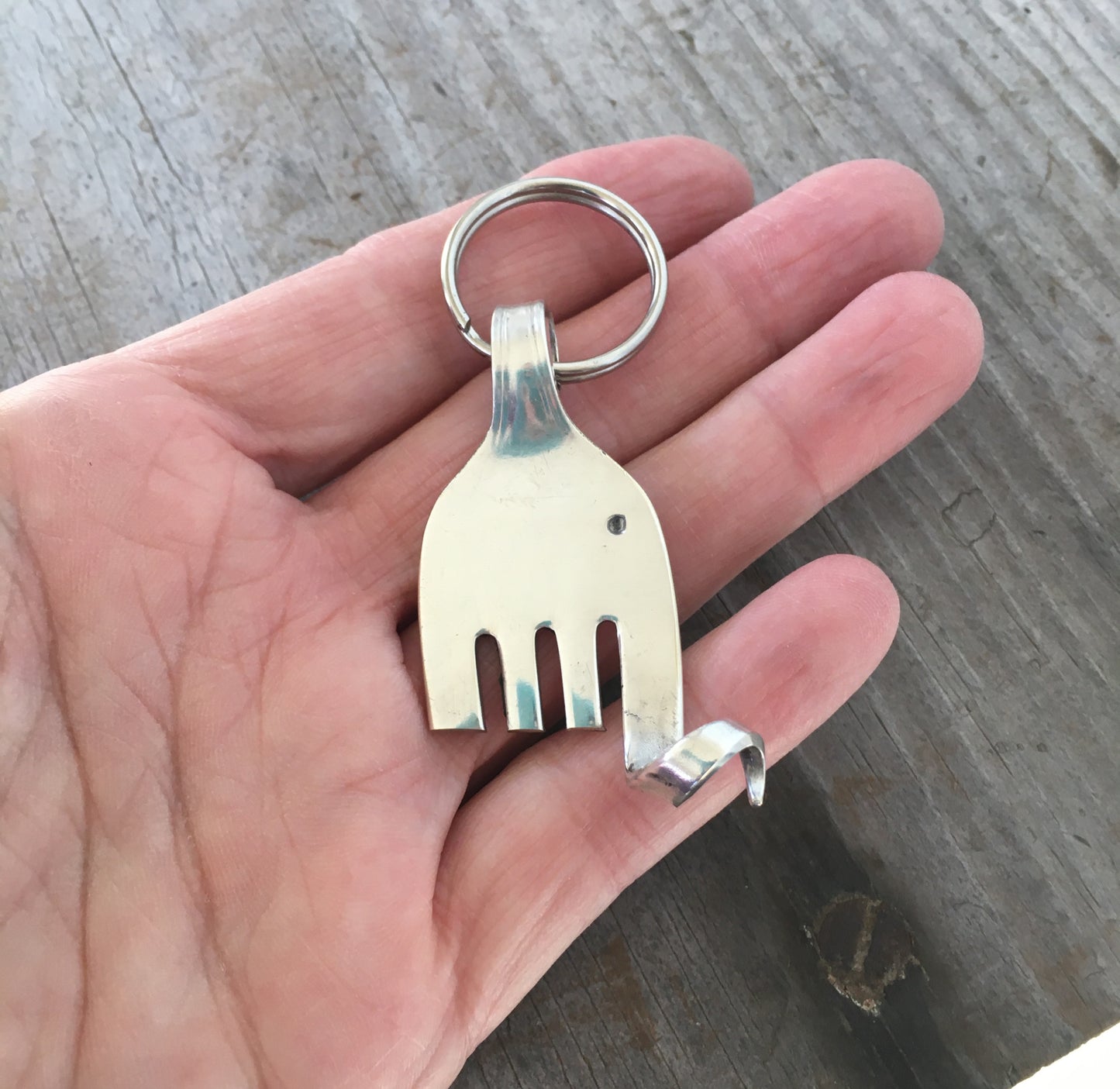 Upcycled silverplate fork elephant keychain charm with personality and vintage patina, one-of-a-kind handmade design shown in hand for scale