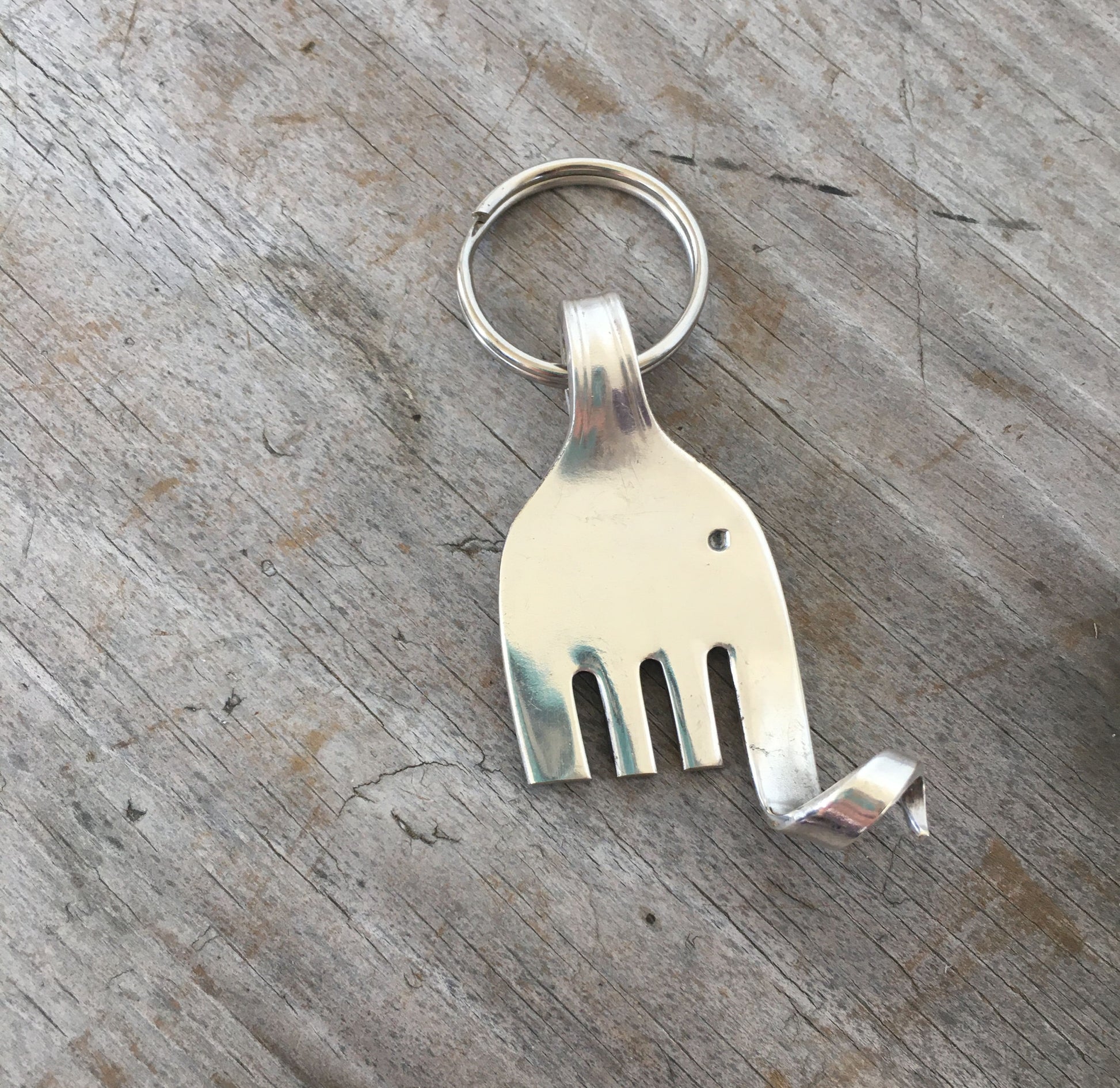 Close-up detail of silverplate fork elephant keychain showing hand-shaped design and polished finish, 2.25 inches long