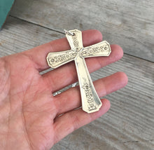 Handmade Cross necklace shown in hand for scale