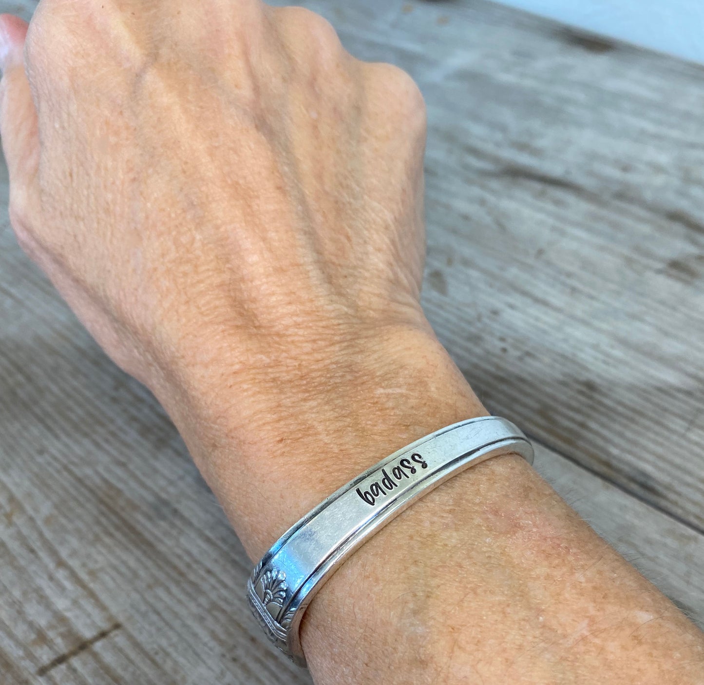 Upcycled silverware spoon cuff bracelet stamped BADASS shown on model