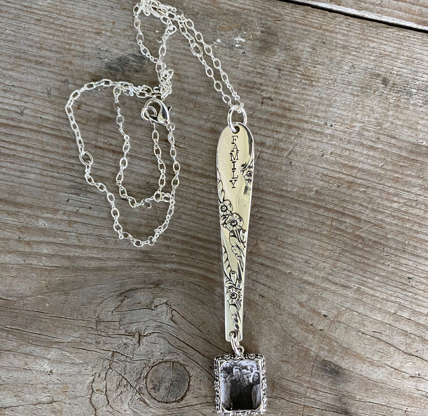 Close-up of FAMILY hand-stamped vintage silverware handle pendant showing Bridal Wreath pattern detail and swappable photo insert