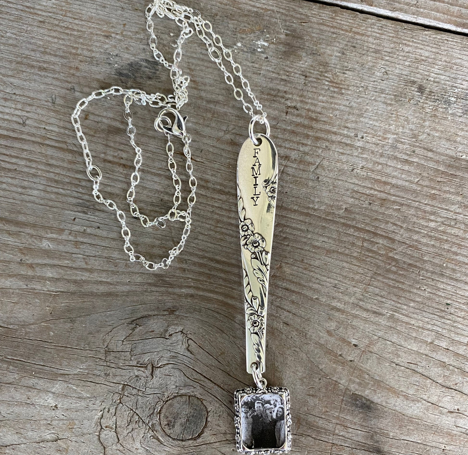 Close-up of FAMILY hand-stamped vintage silverware handle pendant showing Bridal Wreath pattern detail and swappable photo insert