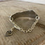 Focus on chain and heart charm on Spread Love Handstamped Upcycled Knife Bracelet