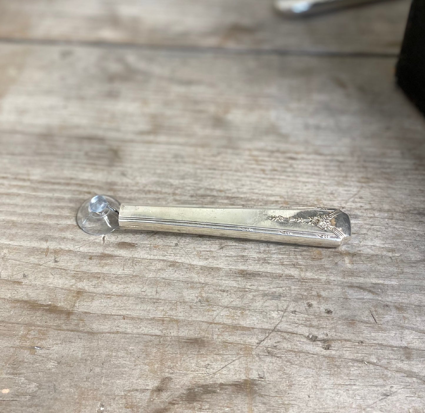 Close-up of handcrafted Community Plate Milady knife vase showing polished hollow handle and suction cup attachment