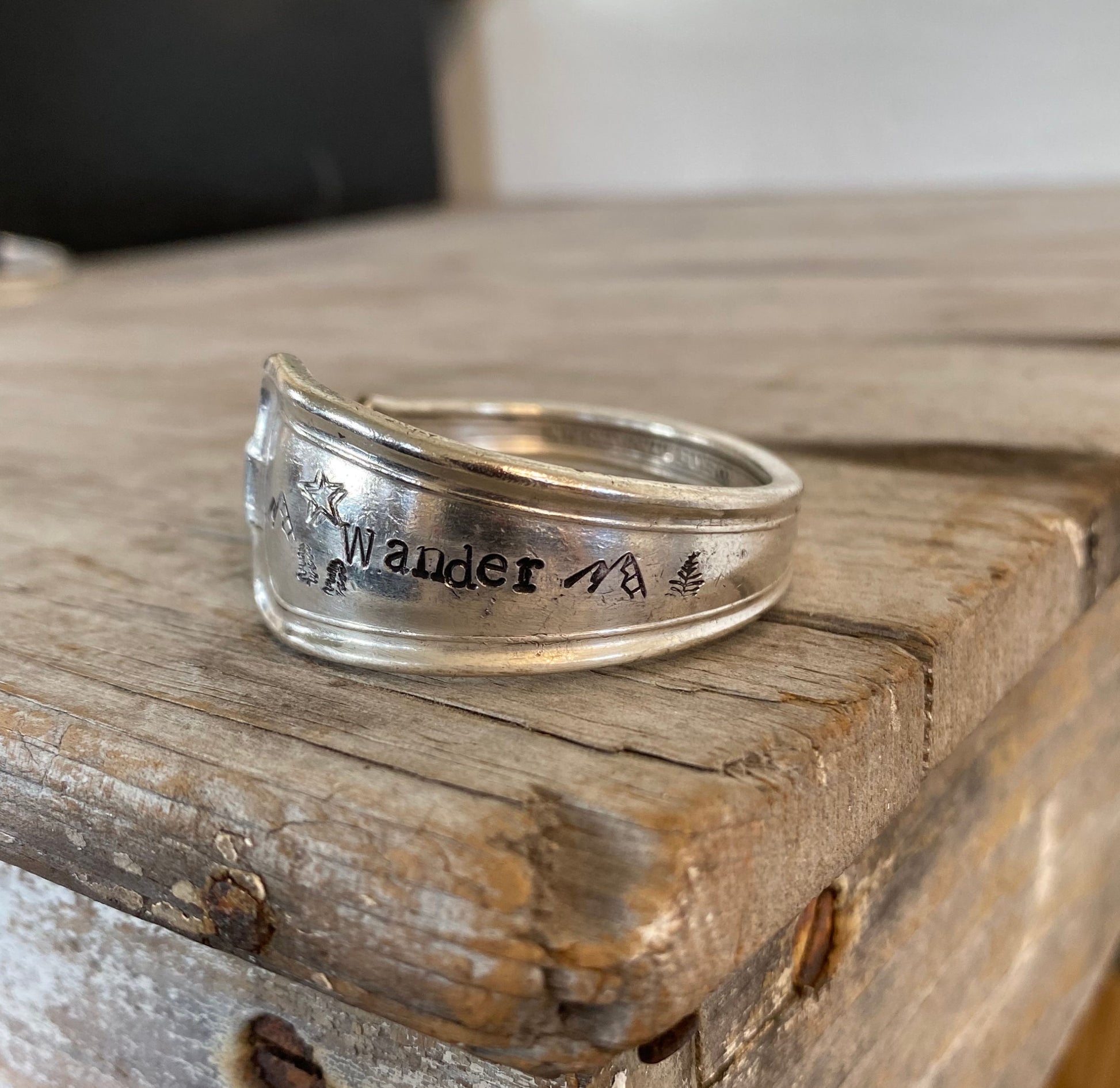 Hand-stamped spoon cuff bracelet from International Silver Cromwell pattern with WANDER message, mountains, trees and star design