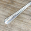 Close-up of Wander hand-stamped lettering on vintage spoon keychain upcycled silverware travel gift