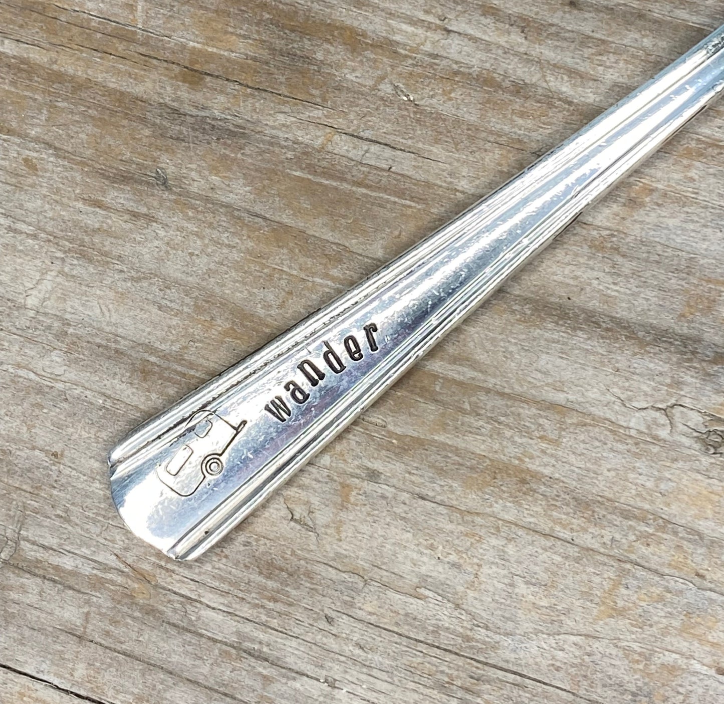 Close-up of Wander hand-stamped lettering on vintage spoon keychain upcycled silverware travel gift