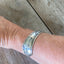 FREE SPIRIT hand-stamped spoon cuff bracelet shown on model wrist - vintage 1936 William A. Rogers silverplate with bohemian message