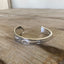 Close-up detail of Meadowbrook/Heather floral pattern on FREE SPIRIT hand-stamped spoon cuff bracelet 