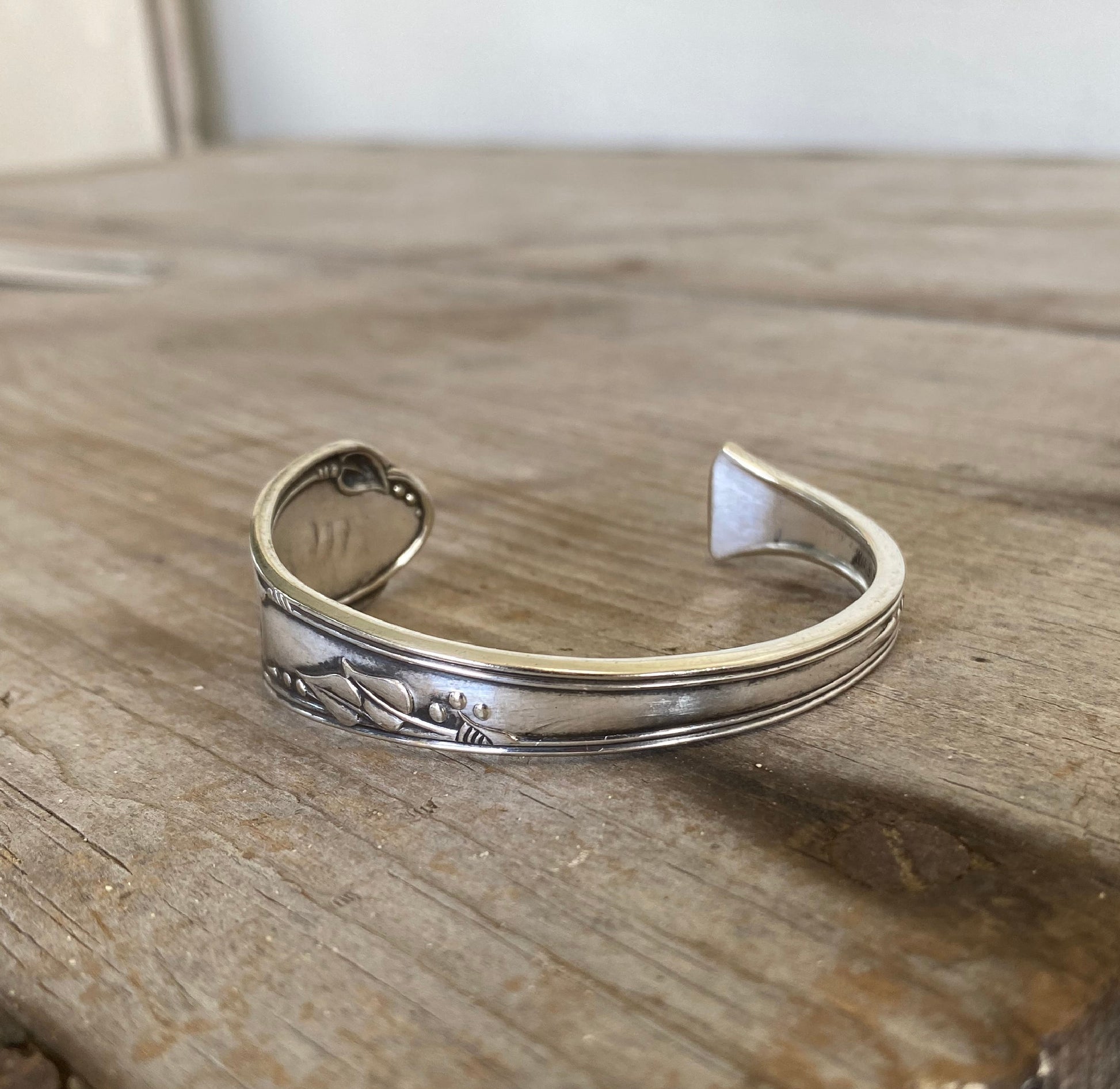 Close-up detail of Meadowbrook/Heather floral pattern on FREE SPIRIT hand-stamped spoon cuff bracelet 
