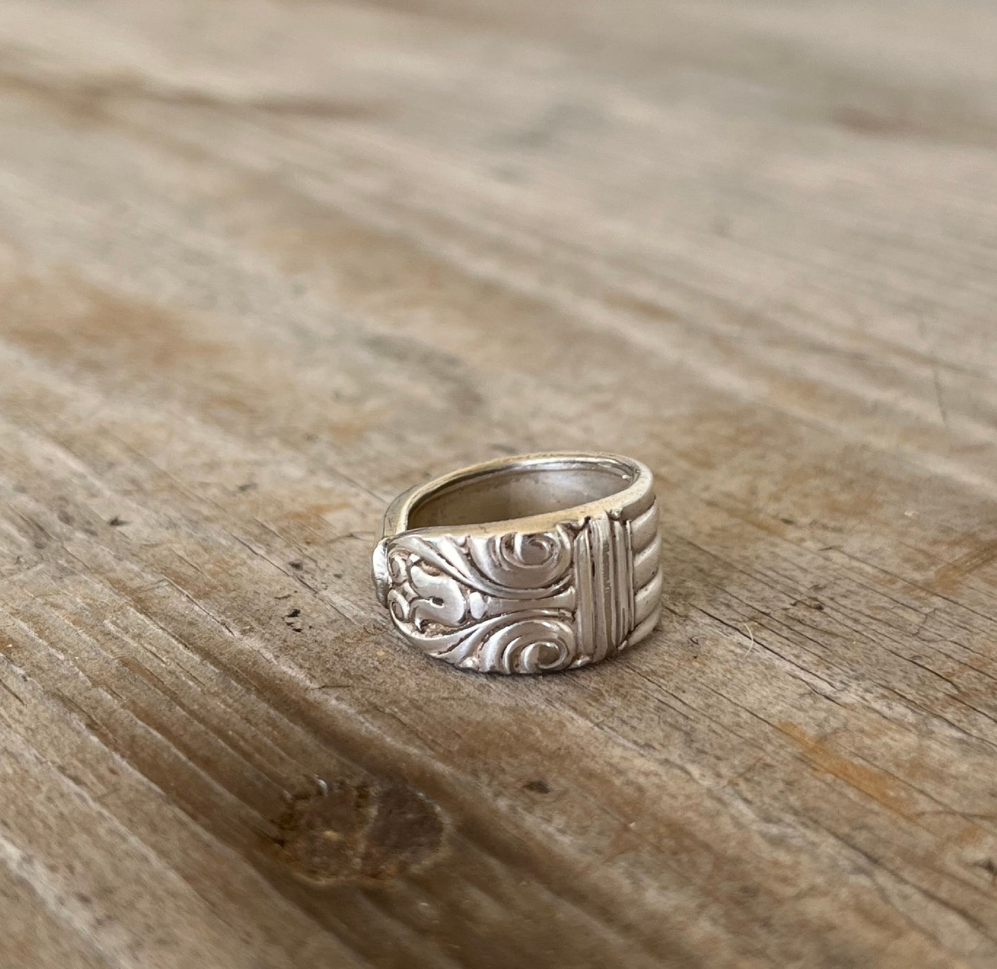 Close-up of DANISH QUEEN pattern spoon ring showing ornate vintage silverware detail