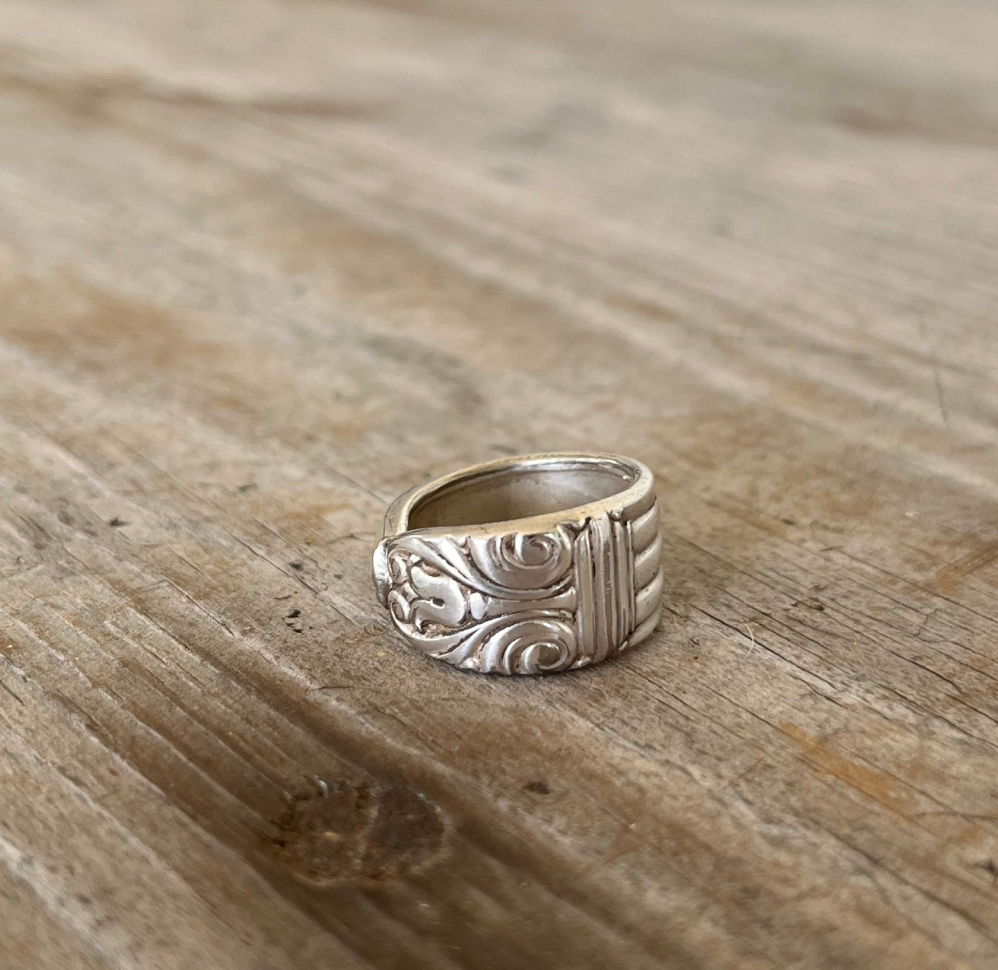 Close-up of DANISH QUEEN pattern spoon ring showing ornate vintage silverware detail