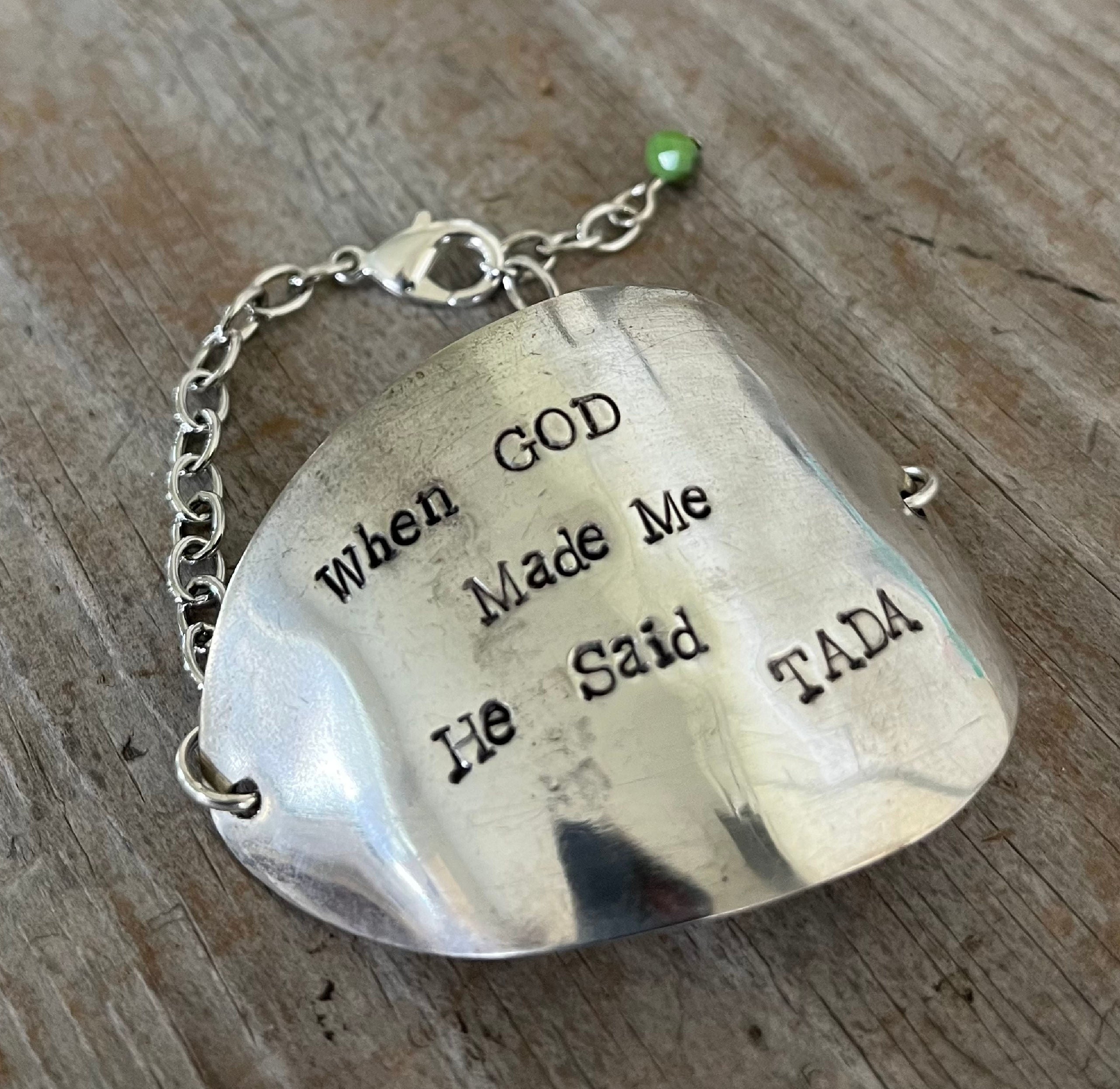 Hand-stamped vintage spoon bracelet with 'When God Made Me He Said TADA' message and green faceted glass bead