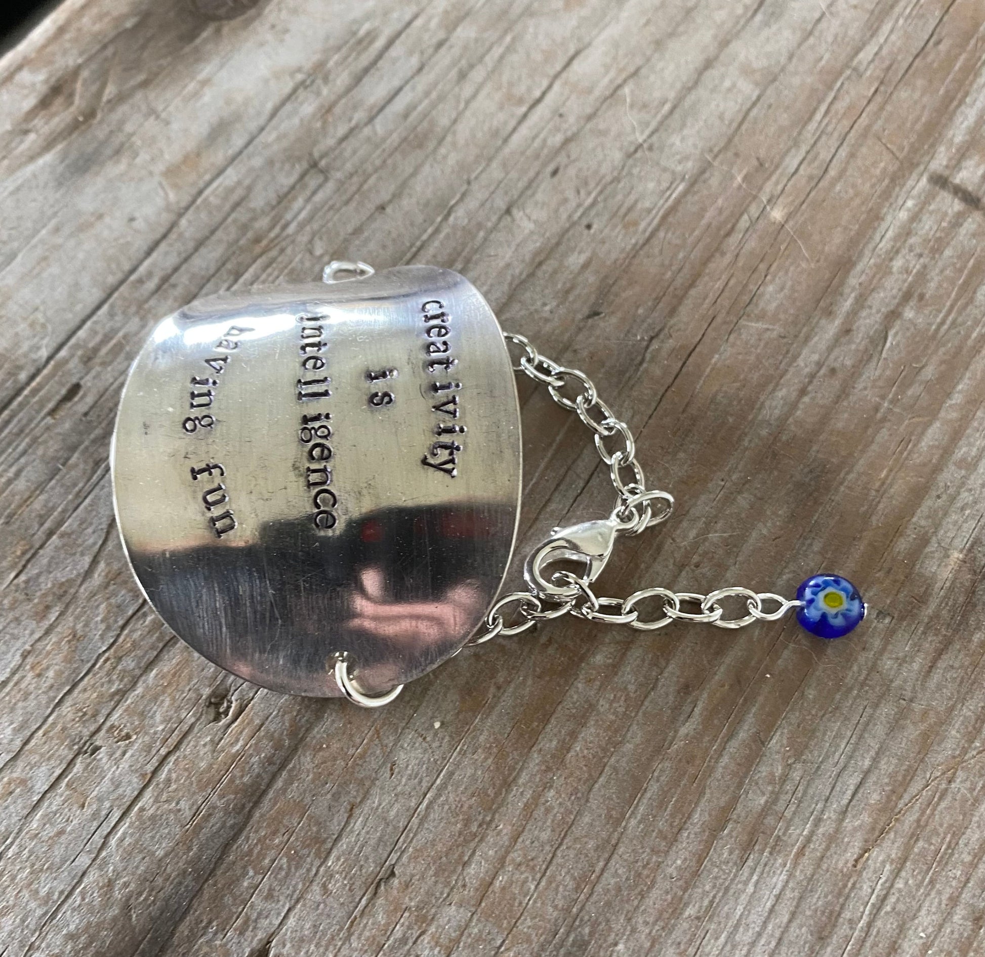 Upcycled silverware stamped spoon bowl bracelet with creativity quote  and blue glass bead accent
