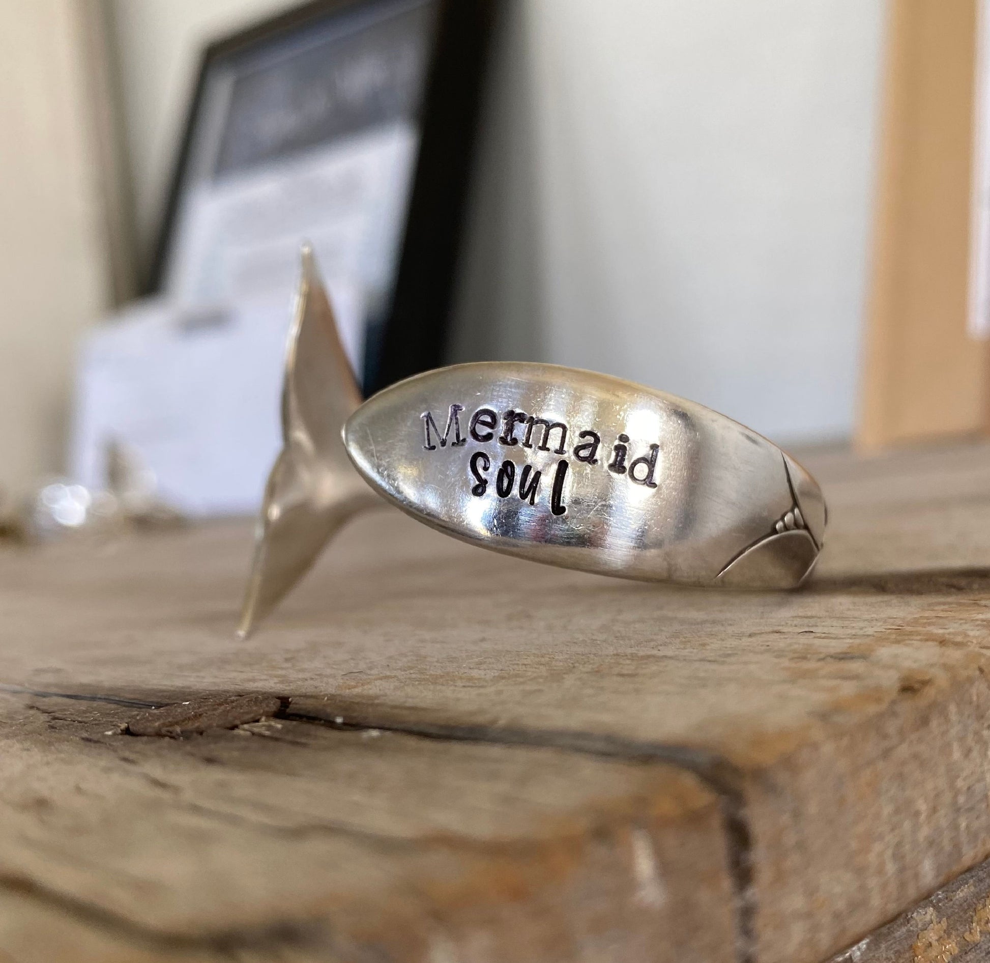 Close-up of hand-stamped Mermaid Soul lettering and carved mermaid tail fin on vintage Lady Hamilton spoon cuff