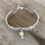 Top view of upcycled silverware jewelry spoon link bracelet with Peridot stone bead